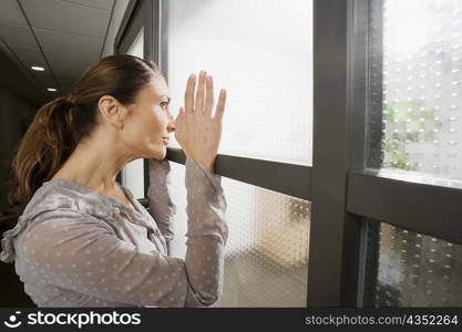 Side profile of a businesswoman looking through a window