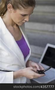 Side profile of a businesswoman operating a mobile phone