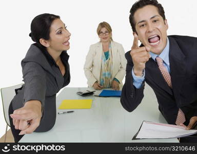 Side profile of a businesswoman pointing at another businessman standing in front of her