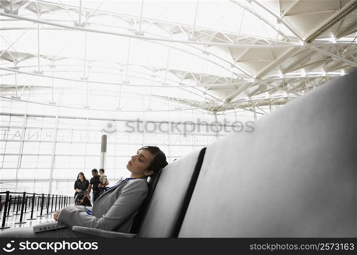 Side profile of a businesswoman sleeping at an airport