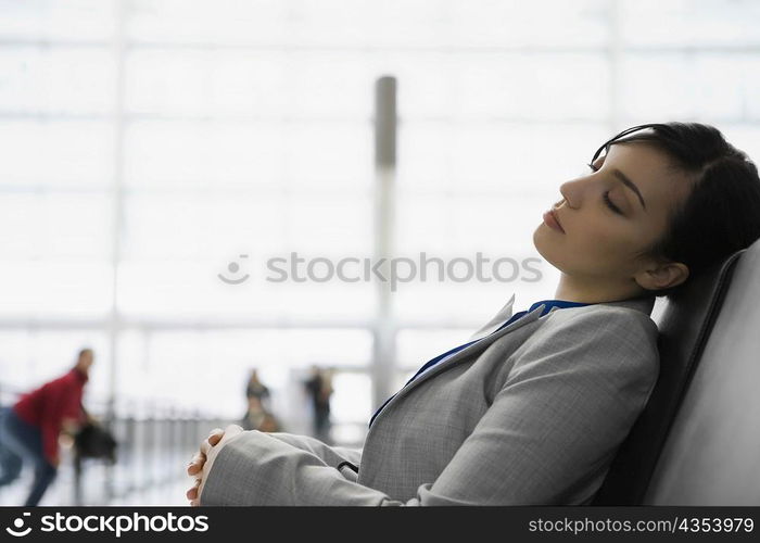 Side profile of a businesswoman sleeping at an airport