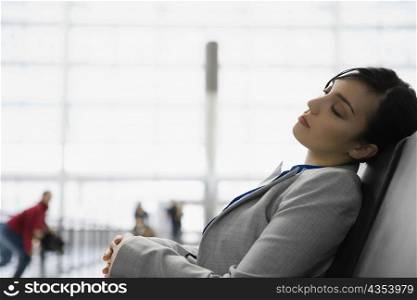 Side profile of a businesswoman sleeping at an airport