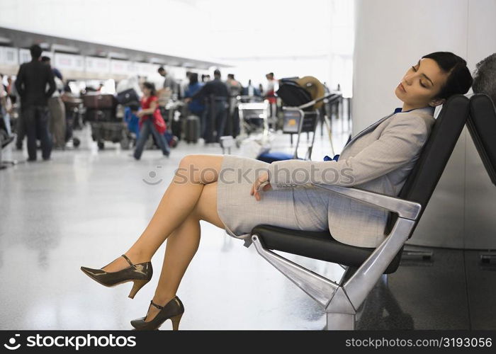 Side profile of a businesswoman sleeping on a chair at an airport