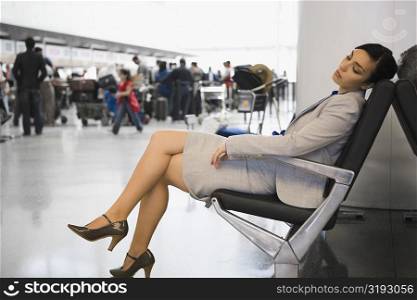 Side profile of a businesswoman sleeping on a chair at an airport