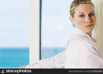 Side profile of a businesswoman standing beside a window