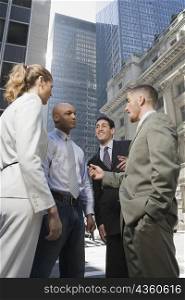 Side profile of a businesswoman standing with three businessmen