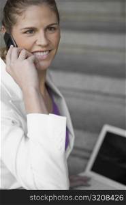 Side profile of a businesswoman talking on a mobile phone and smiling