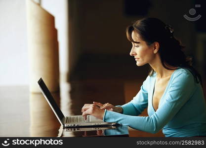 Side profile of a businesswoman typing on a laptop