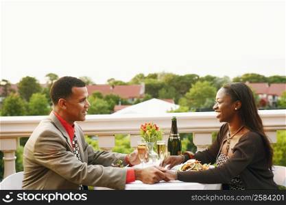 Side profile of a couple sitting at a table and smiling