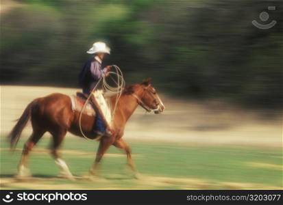 Side profile of a cowboy riding a horse, Texas, USA