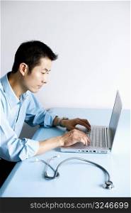 Side profile of a doctor operating a laptop