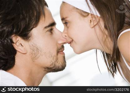 Side profile of a father and his daughter nuzzling