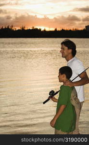 Side profile of a father and his son fishing