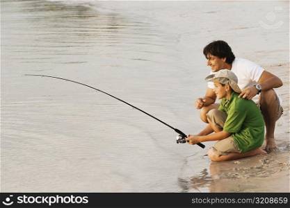 Side profile of a father and his son fishing