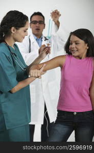 Side profile of a female doctor giving an injection to a girl