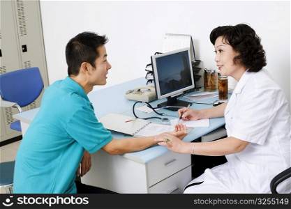 Side profile of a female doctor taking a patient&acute;s pulse