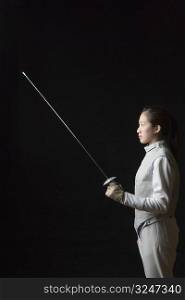 Side profile of a female fencer holding a fencing foil