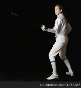 Side profile of a female fencer holding a fencing foil