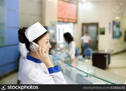 Side profile of a female nurse talking on the telephone