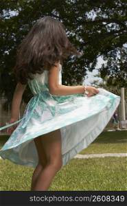 Side profile of a girl dancing in a park
