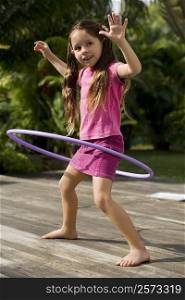 Side profile of a girl playing with a plastic hoop