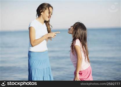 Side profile of a girl pointing to her sister