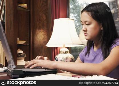 Side profile of a girl using a laptop