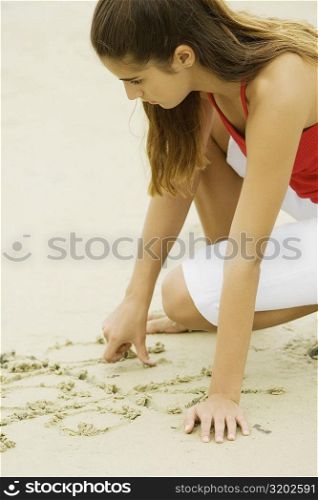 Side profile of a girl writing in sand
