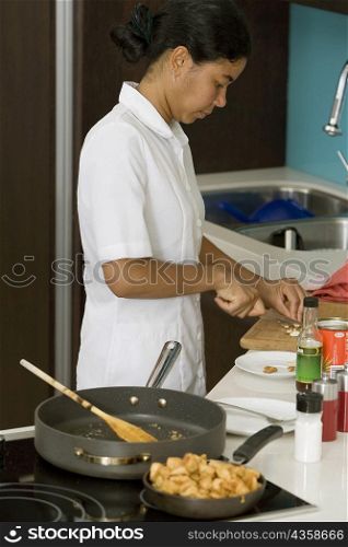 Side profile of a maid preparing food in the kitchen