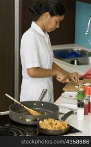 Side profile of a maid preparing food in the kitchen