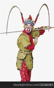 Side profile of a male Chinese opera performer gesturing with a weapon