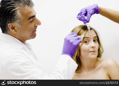 Side profile of a male doctor injecting a female patient