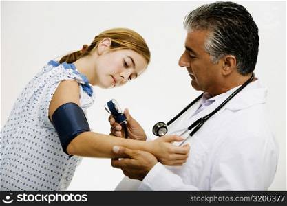 Side profile of a male doctor measuring blood pressure of a young woman