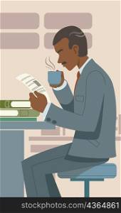 Side profile of a man drinking a cup of coffee and reading a book