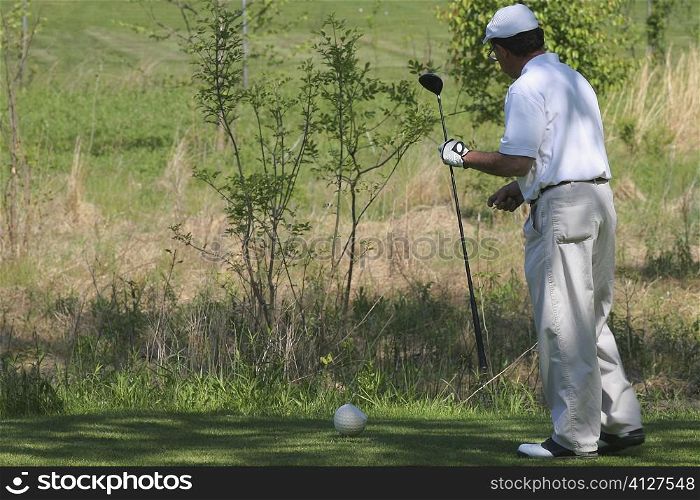 Side profile of a man holding a golf club
