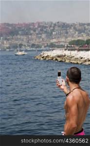 Side profile of a man photographing with a mobile phone, Bay of Naples, Naples, Naples Province, Campania, Italy