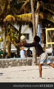 Side profile of a man playing volleyball on the beach, Miami, Florida, USA