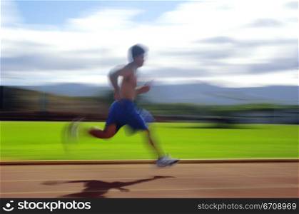 Side profile of a man running on a track