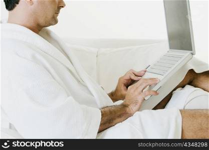 Side profile of a man using a laptop