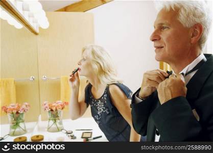 Side profile of a mature couple dressing up in the bathroom