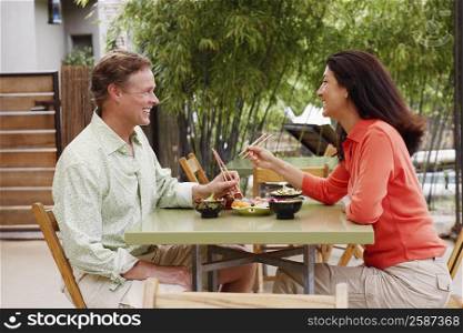 Side profile of a mature couple sitting at a table and smiling