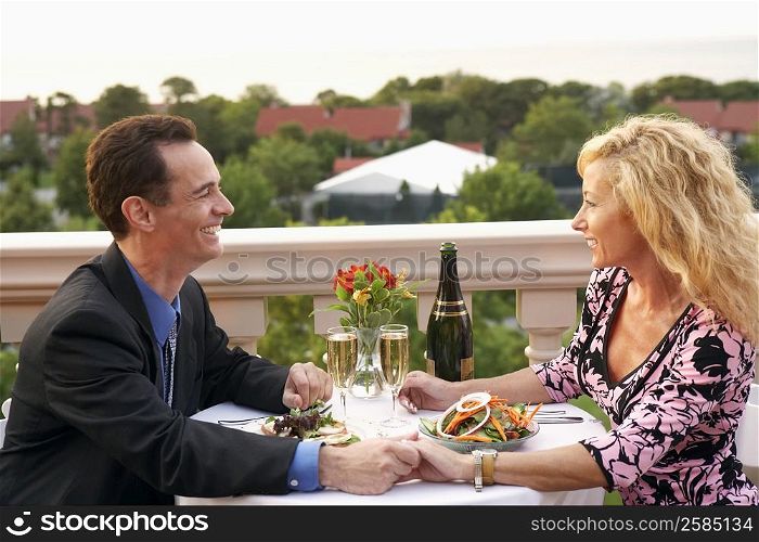 Side profile of a mature couple sitting at the table and smiling