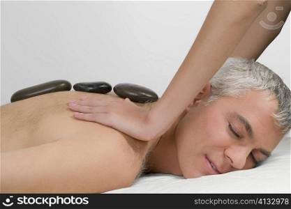 Side profile of a mature man getting a shoulder massage from a massage therapist