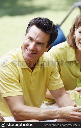 Side profile of a mature man holding a glass of lemonade