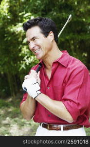 Side profile of a mature man holding a golf club