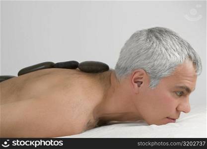 Side profile of a mature man receiving a lastone therapy