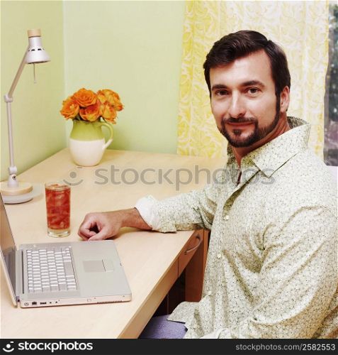 Side profile of a mature man sitting in front of a laptop