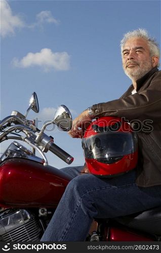 Side profile of a mature man sitting on a motorcycle