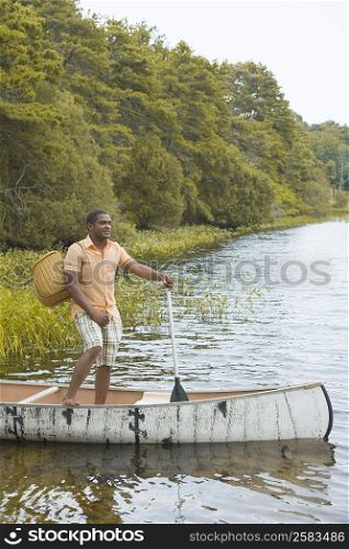 Side profile of a mature man standing in a canoe