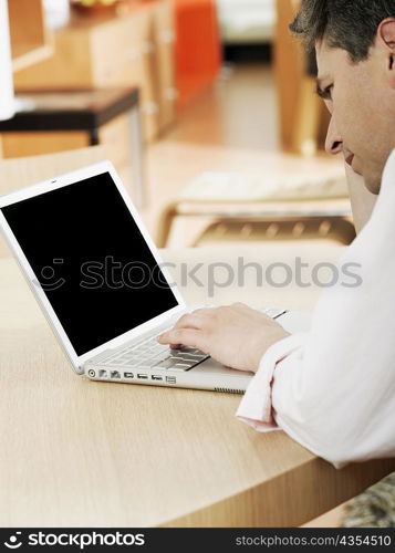 Side profile of a mature man using a laptop